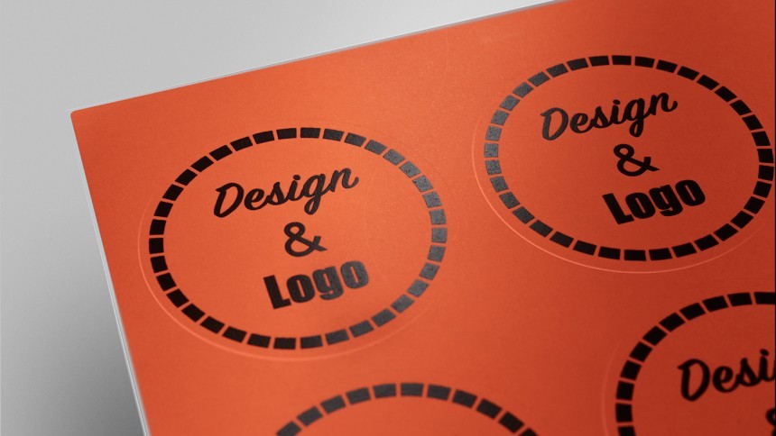 Rdeče okrogle neprosojne nalepke z natisnjenim črnim napisom "Design & Logo" na listu A4 formata