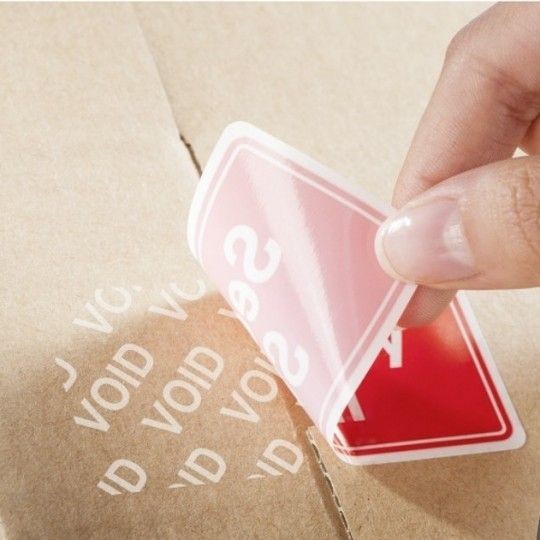 Prikaz uporabe opozorilnih etiket s predtiskom Security Seal: etikete po odstranitvi puscajo odtis Void