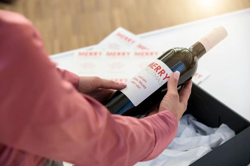 Oseba lepi potiskano etiketo na steklenico