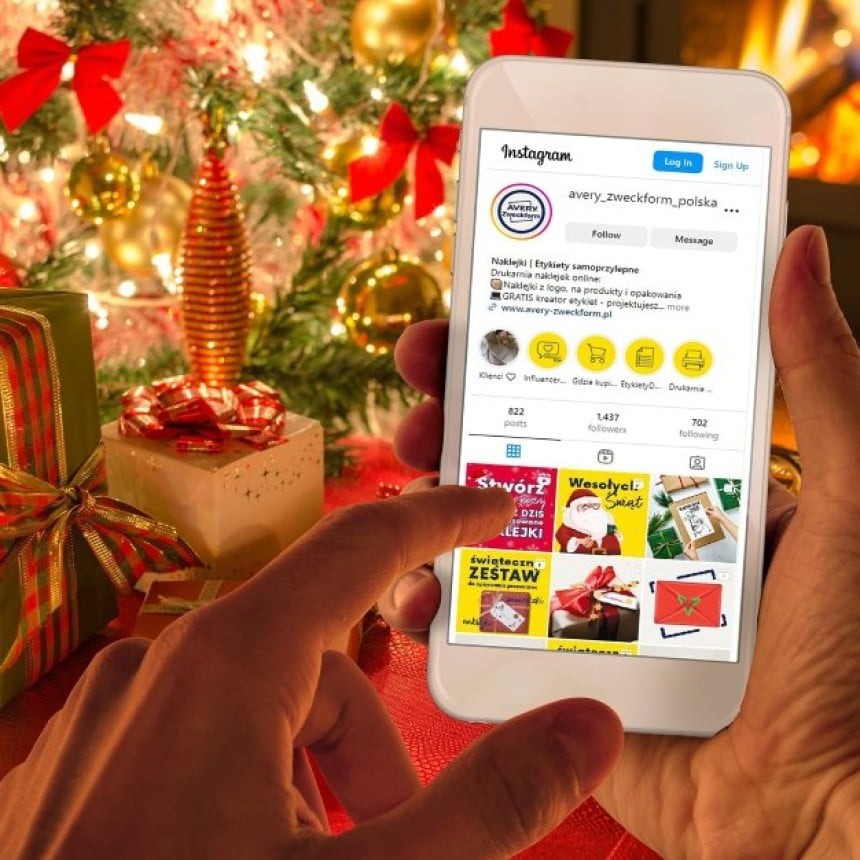 Okrašena jelka in božična darila ter telefon z instragramom