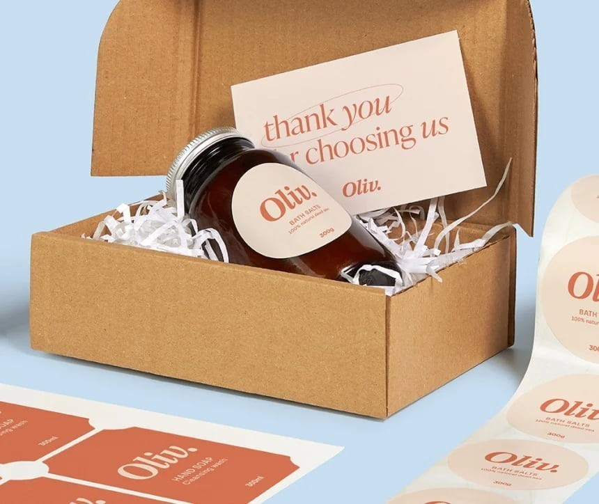 Kartoska škatlica z stekleničko oliv in pismom z zahvalo.