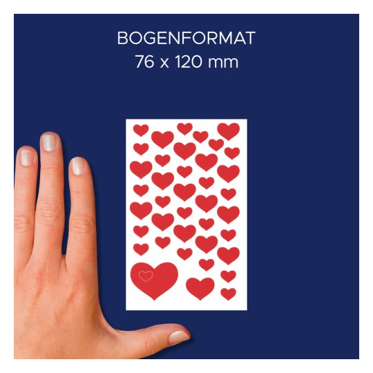 Slika prikazuje roko poleg kartice, pokrite s številnimi nalepkami rdečih src, kar nakazuje velikost 76 x 120 mm.