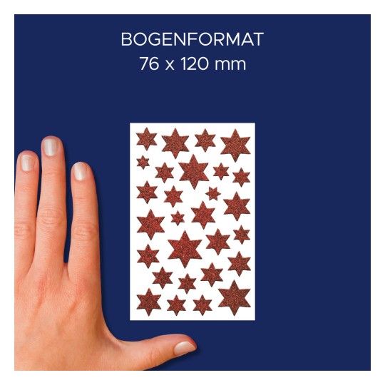 Slika prikazuje roko poleg lista z okrasnimi zvezdnatimi nalepkami. Nalepke so različnih velikosti, bleščeče rdeče barve, na beli podlagi. Dimenzije lista so navedene kot 76 x 120 mm.