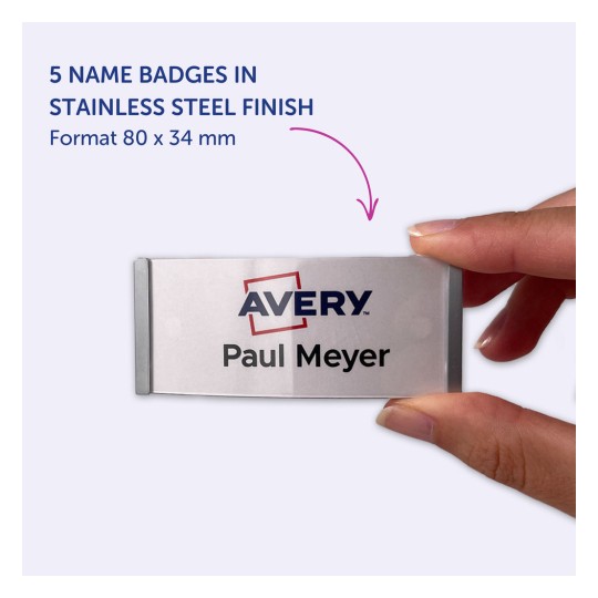 Slika prikazuje roko, ki drži značko iz nerjavečega jekla z napisom 'Avery' in imenom 'Paul Meyer'. Označuje, da je v tem formatu pet značk, ki merijo 80 x 34 mm.