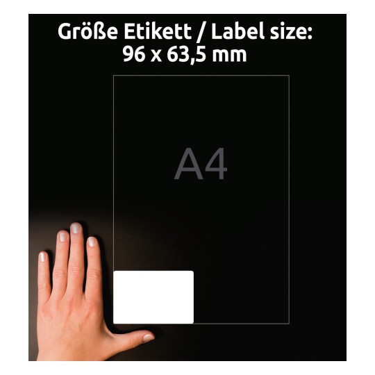 Slika prikazuje roko poleg nalepke. Velikost nalepke je navedena kot 96 x 63,5 mm, z velikostjo A4 navedeno za njo. Ozadje je temno, kar izboljša vidljivost predmetov.