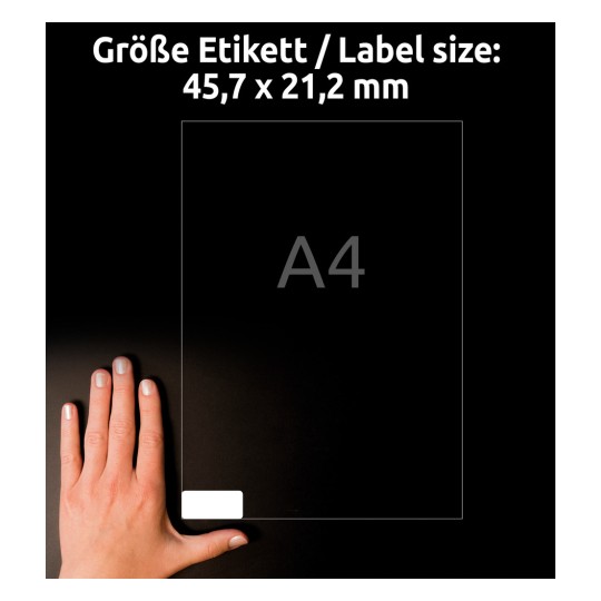 Slika prikazuje roko na temnem ozadju, ki drži nalepko velikosti 45,7 x 21,2 mm, označeno z 'A4'.