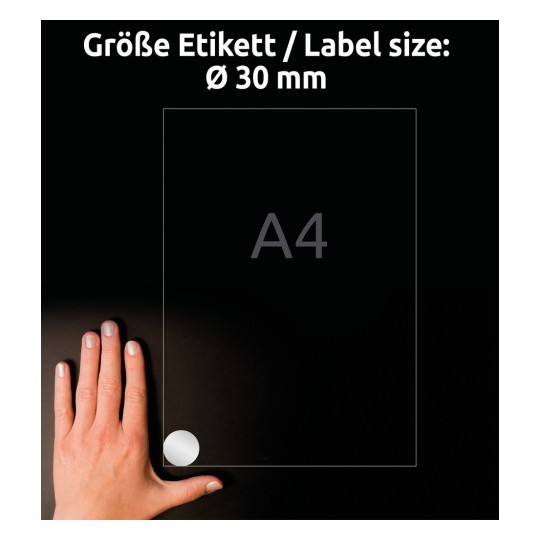 Slika prikazuje roko, položeno na temno površino poleg lista formata A4, označenega z okroglim nalepko s premerom 30 mm.