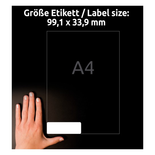 Slika prikazuje roko poleg etikete velikosti 99,1 x 33,9 mm z omenjeno velikostjo A4. Ozadje je temno, etiketa pa se zdi bela.