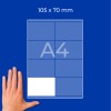 Roka ob listu A4 z mrežo, označeno 105 x 70 mm, na modrem ozadju?
