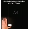 Slika prikazuje roko poleg nalepke formata A4 z dimenzijami 45,7 x 21,2 mm. Ozadje je temno, kar poudarja vidljivost nalepke in roke.