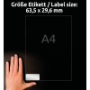 Slika prikazuje roko, ki drži prozorno nalepko z napisom, ki označuje velikost nalepke 63,5 x 29,6 mm, ob referenci velikosti papirja A4.