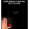 Slika prikazuje velikost nalepke 45,7 x 21,2 mm poleg roke, z označeno velikostjo papirja A4. Položaj nalepke je označen z rdečim delom.