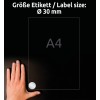 Slika prikazuje roko, položeno na temno površino poleg lista formata A4, označenega z okroglim nalepko s premerom 30 mm.