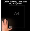 Slika prikazuje roko, ki drži nalepko ali dokument z dimenzijami 45,7 x 25,4 mm, poleg velikosti črke A4, na temnem ozadju.